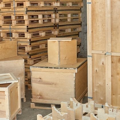A collection of custom timber packaging solutions by Trafalgar Cases, showcasing durable plywood cases, open slatted timber crates, and specialized pallets, designed to protect and transport industrial goods efficiently.