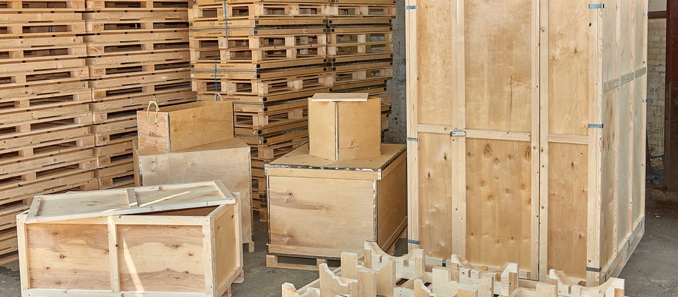 A collection of custom timber packaging solutions by Trafalgar Cases, showcasing durable plywood cases, open slatted timber crates, and specialized pallets, designed to protect and transport industrial goods efficiently.